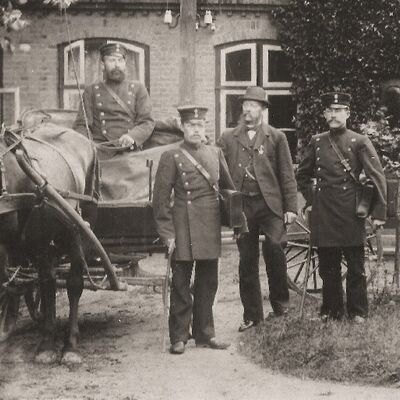 1882 die Kaiserlichen Postbeamten in der damaligen Postuniform vor ihrer Dienststelle, der Hufe von Heinrich Friedrich Stoltenberg im Blomeweg.